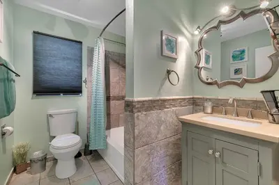 a bathroom with a toilet and a sink and a mirror at Family Vacation Villa, Water Park, Endless Amenities in Kissimmee