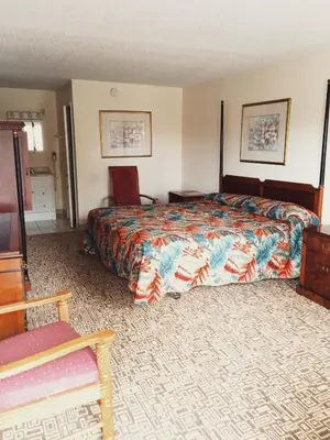 a hotel room with a bed and a chair at The keys in Kissimmee