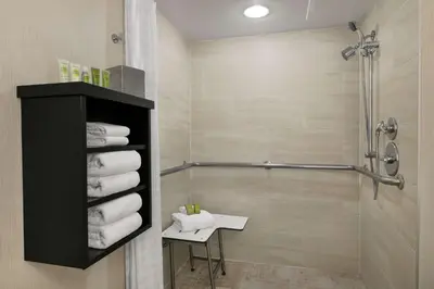 a bathroom with a shower and a sink and towels at Hilton Orlando/Altamonte Springs in Orlando