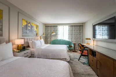 a hotel room with two beds and a desk at Castle Hotel, Autograph Collection in Orlando