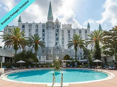 a hotel with a swimming pool in front of a building at Castle Hotel, Autograph Collection in Orlando