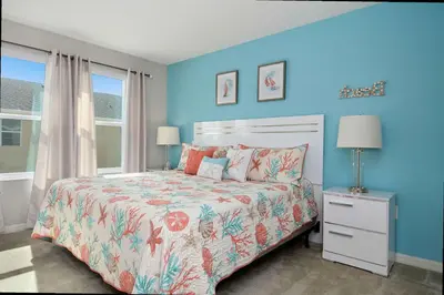 a bedroom with a bed and a blue wall at Four Bedrooms TownHome 5122 in Kissimmee