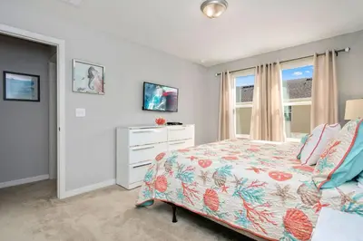 a bedroom with a bed and a dresser and a window at Four Bedrooms TownHome 5122 in Kissimmee