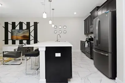a kitchen with a black refrigerator and a table at Four Bedrooms w/ Pool TownHome 4841 in Kissimmee