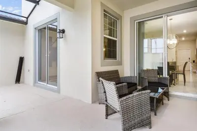 a porch with chairs and a table and a dining room at Four Bedrooms w/ Pool TownHome 4841 in Kissimmee
