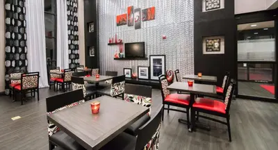 a dining room with tables and chairs in a restaurant at Hampton Inn & Suites Orlando-John Young Parkway/South Park in Orlando