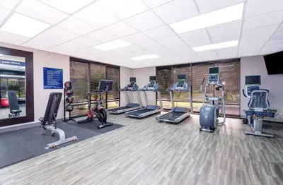 a gym with several treadmills and cardio machines at Hampton Inn Orlando-International Airport in Orlando