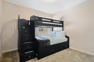 a bedroom with a black bunk bed and a dresser at Four Bedrooms TownHome 5130 in Kissimmee
