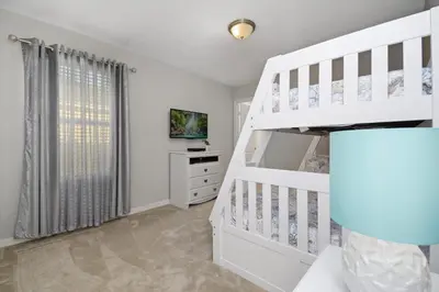 a white bedroom with a bunk bed and a white staircase at Four Bedrooms Resort TownHome 5128 in Kissimmee