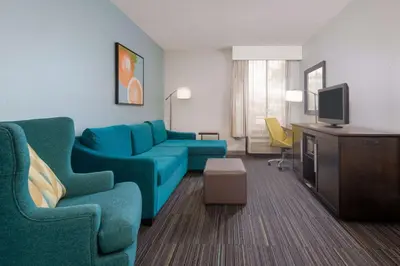 a living room with a couch and a tv at Hampton Inn Orlando Near Universal Blv/International Dr in Orlando