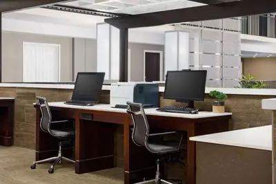 an office with two computers on a desk with chairs at Embassy Suites by Hilton Orlando Lake Buena Vista Resort in Orlando