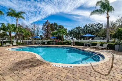 a swimming pool with a brick patio and palm trees at Hampton Inn Lake Buena Vista / Orlando in Orlando