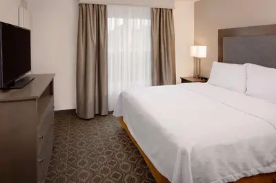 a hotel room with a bed and a flat screen tv at Homewood Suites by Hilton Orlando Maitland in Orlando