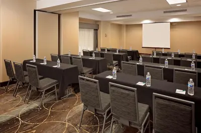 a conference room with tables and chairs and a whiteboard at Homewood Suites by Hilton Orlando Maitland in Orlando