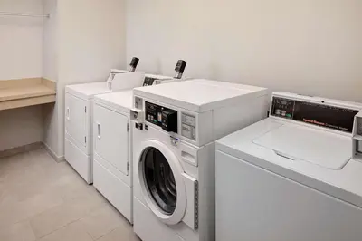 a white laundry room with a washer and dryer at Homewood Suites by Hilton Orlando Maitland in Orlando
