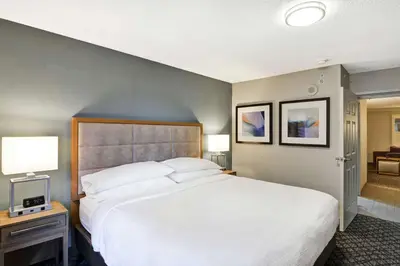 a bedroom with a large white bed and two lamps at Embassy Suites by Hilton Orlando Downtown in Orlando