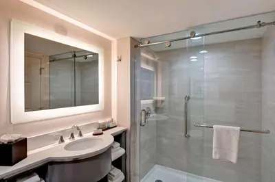 a bathroom with a sink and a shower at Embassy Suites by Hilton Orlando Downtown in Orlando