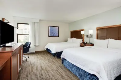 a hotel room with two beds and a flat screen tv at Hampton Inn Orlando International Drive Convention Center in Orlando