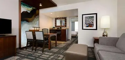 a living room with a couch and a dining room at Embassy Suites by Hilton Orlando International Drive Convention Center in Orlando