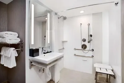 a white bathroom with a sink and a shower at Embassy Suites by Hilton Orlando International Drive Convention Center in Orlando