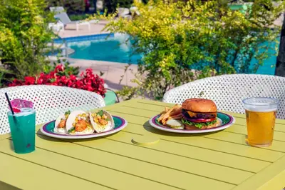 a table with two plates of food and two drinks at Hilton Garden Inn Orlando International Drive North in Orlando