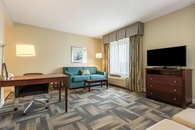 a hotel room with a desk and a television at Hampton Inn & Suites Orlando-South Lake Buena Vista in Kissimmee