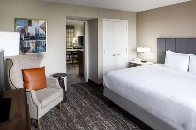a hotel room with a bed and a chair at Embassy Suites by Hilton Orlando North in Orlando