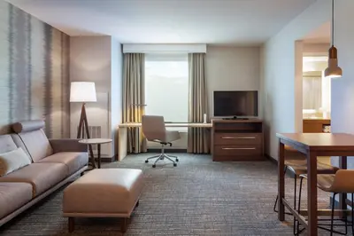 a hotel room with a couch and a desk and a television at Residence Inn by Marriott Orlando at Millenia in Orlando