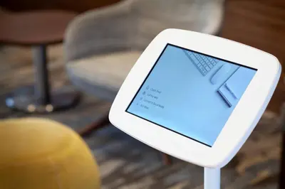 a tablet on a stand in front of a chair at SpringHill Suites by Marriott Orlando at Millenia in Orlando