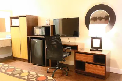 a room with a desk with a chair and a television at Orlando Inn International Drive Area in Orlando