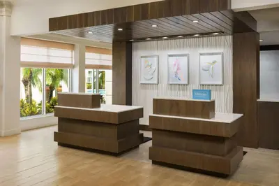 a lobby with two counters and paintings on the wall at Hilton Garden Inn Lake Mary in Lake Mary