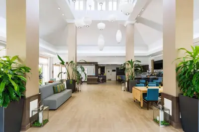 an office lobby with potted plants and furniture at Hilton Garden Inn Lake Mary in Lake Mary
