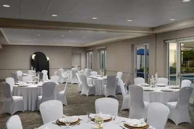 a room with white tables and white chairs and tablesearcher at Hilton Garden Inn Lake Mary in Lake Mary