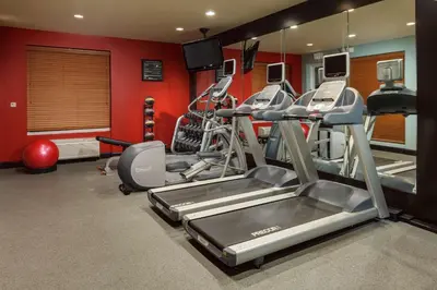 a gym with cardio equipment in a room with red walls at Hilton Garden Inn Lake Mary in Lake Mary