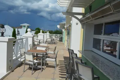 a balcony with tables and chairs on a building at Disney Dreams Luxury Home with Private Water Park in Orlando