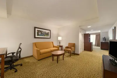 a hotel room with a couch and a chair and a table at Hilton Garden Inn Orlando East - UCF Area in Orlando