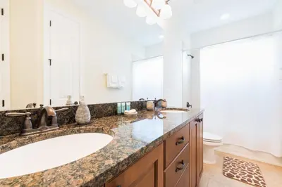 a bathroom with a large sink and a large mirror at Luxury Dreams Disney Home with Private Pool and Spa in Orlando