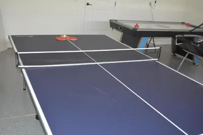 a ping pong table with a ping pong racket on it at Luxury Dreams Disney Home with Private Pool and Spa in Orlando
