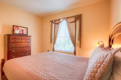 a bedroom with a bed and a dresser and a window at Lovely Third-Floor Vista Cay Resort Condo in Orlando