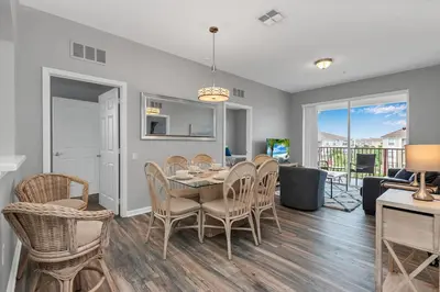 a dining room and living room with a table and chairs at Penthouse Paradise in Orlando