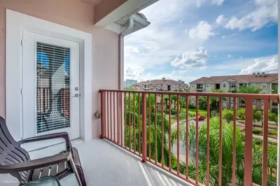 a balcony with a chair and a view of a yard at Stunning Top-Floor Condo, next to Clubhouse in Orlando