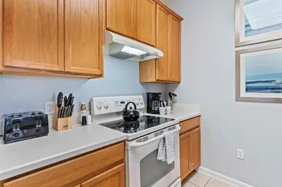 a kitchen with wooden cabinets and a stove top oven at Tropical Treasure in Orlando