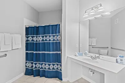 a bathroom with a blue shower curtain and a sink at Tropical Treasure in Orlando