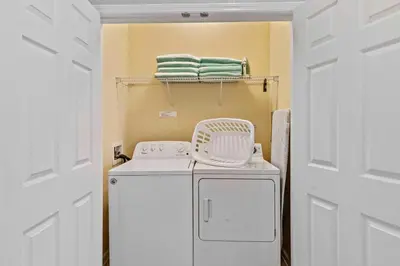 a laundry room with a washing machine and towels at Tropical Treasure in Orlando