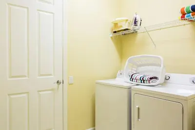 a laundry room with a washing machine with a basket on it at Florida Palms in Orlando