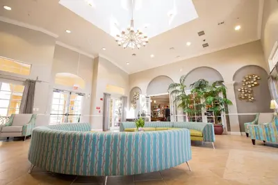 a lobby with blue couches and a chandelier at Florida Palms in Orlando