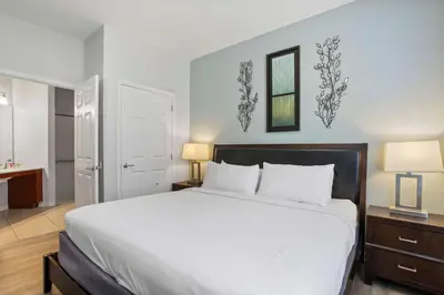 a bedroom with a large white bed and two lamps at Cozy Condo w FREE Vista Cay Resort Access in Orlando