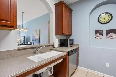 a kitchen with a sink and a clock on the wall at Cozy Condo w FREE Vista Cay Resort Access in Orlando