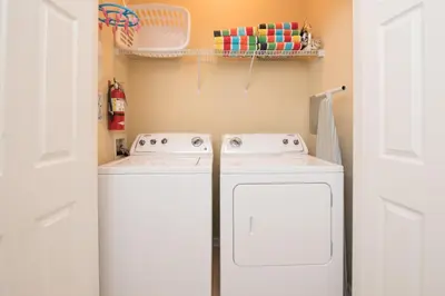 a white washer and dryer in a small kitchen at Luxurious Condo w Modern Design, near Disney in Orlando