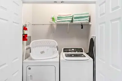 a small kitchen with a stove and towels at Modern Vista Cay Condo, near Universal Studios in Orlando